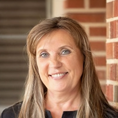Dental Assistant Virginia Smiling In Front Of Brick Wall